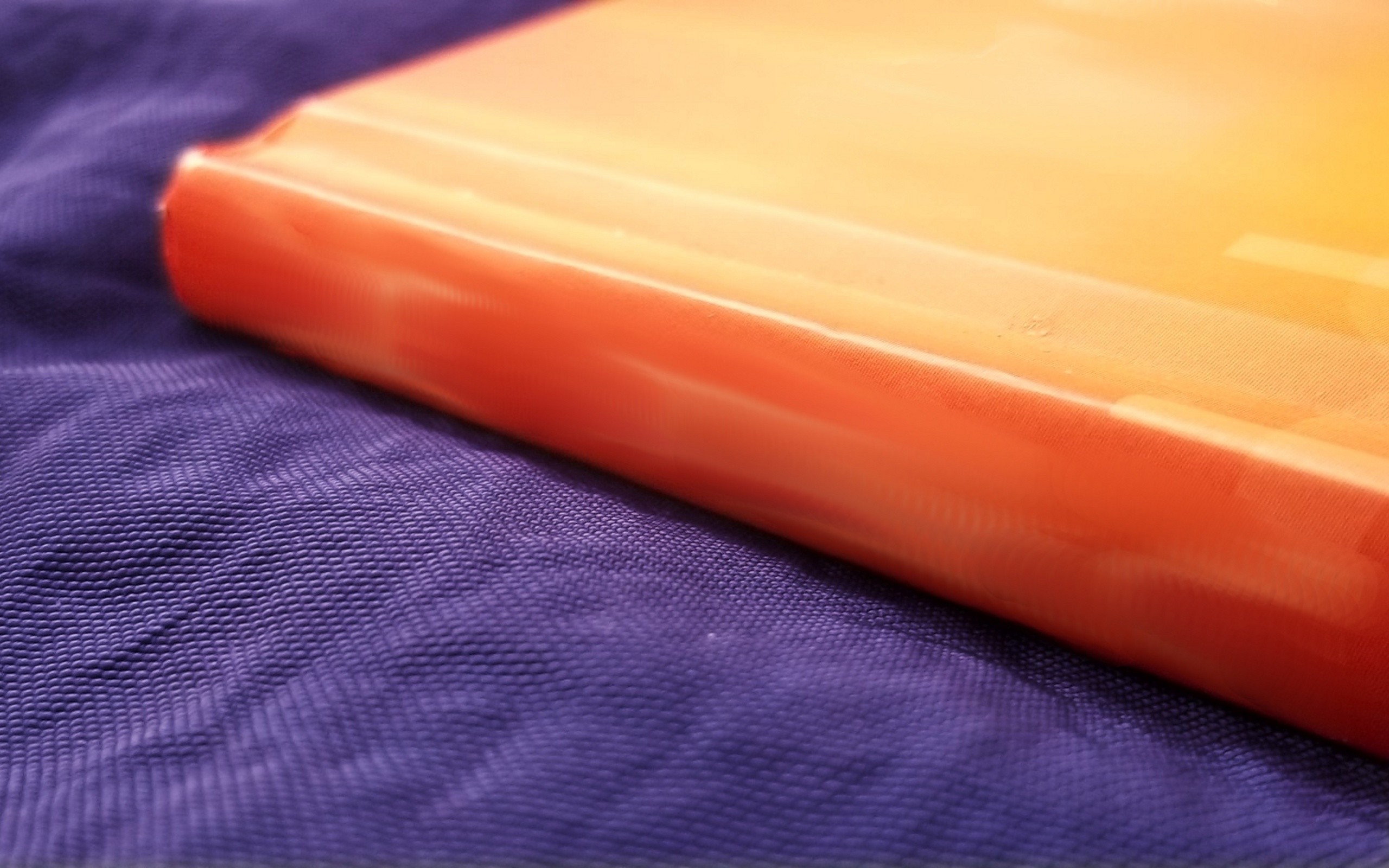 orange book on purple fabric