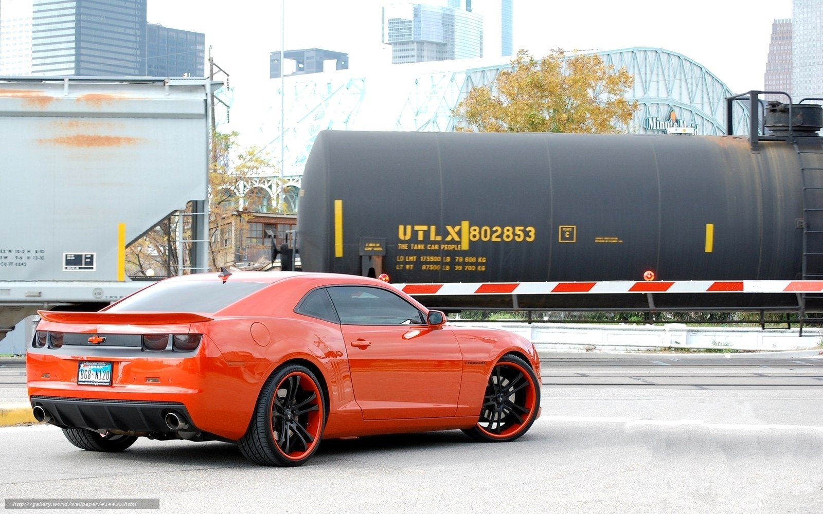 Orange Camaro near train