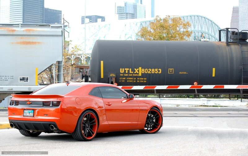 Orange Camaro near train