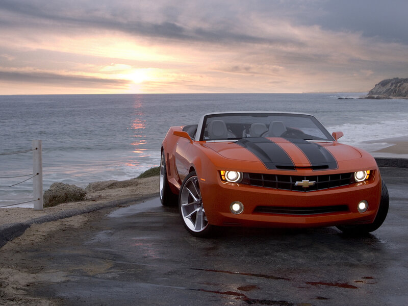 Orange Camaro on coastal road