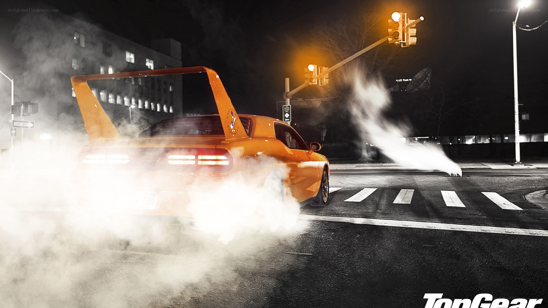 Orange car doing burnout at night