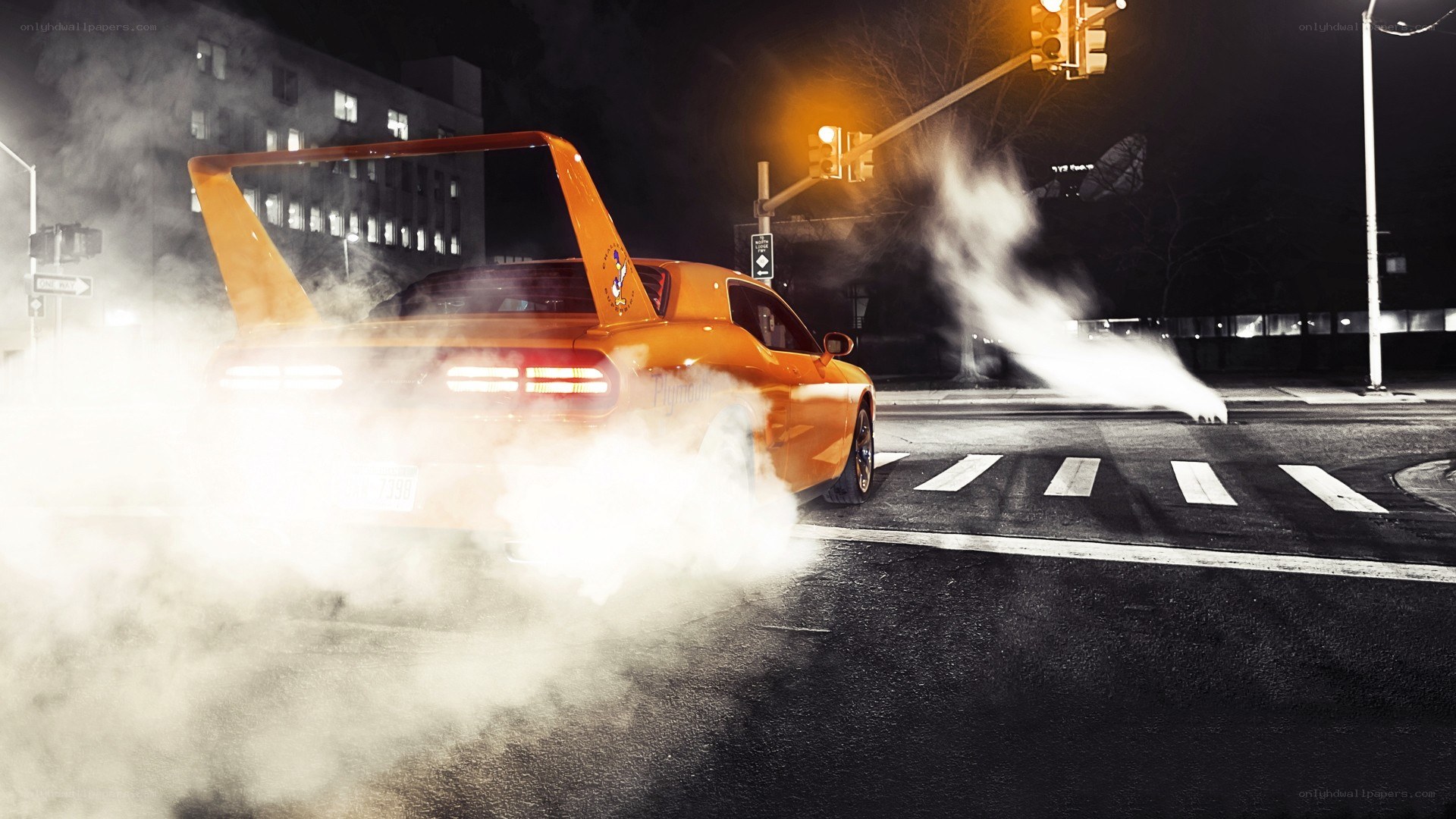 Orange car doing burnout at night