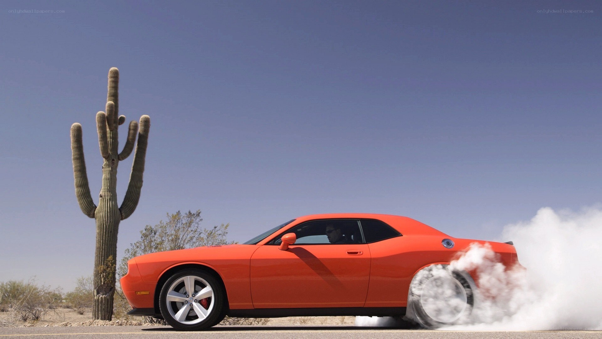 Orange car doing burnout in desert