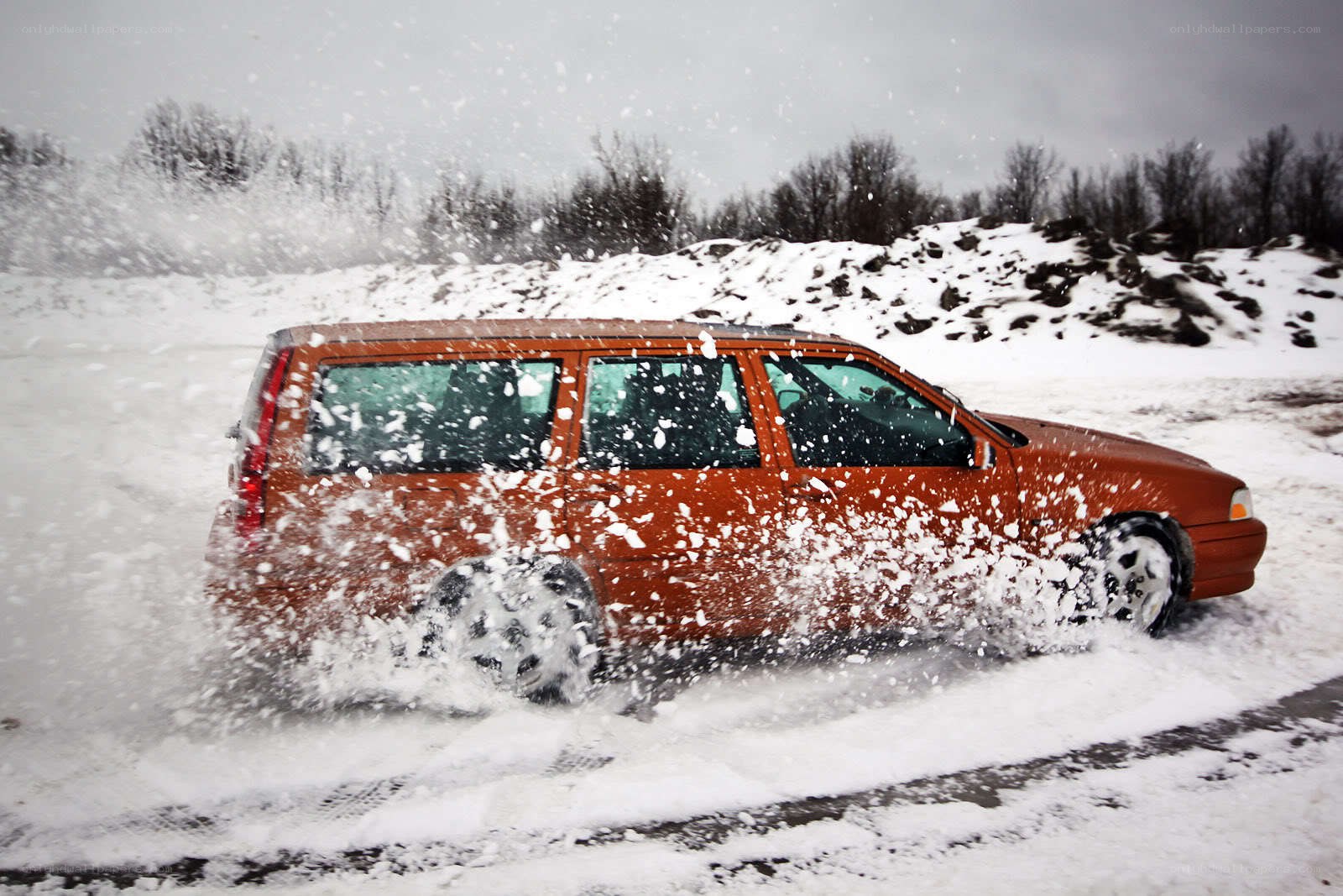 Orange car driving in snow