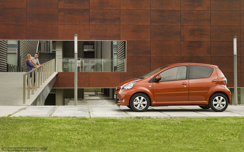 Orange car parked near modern building