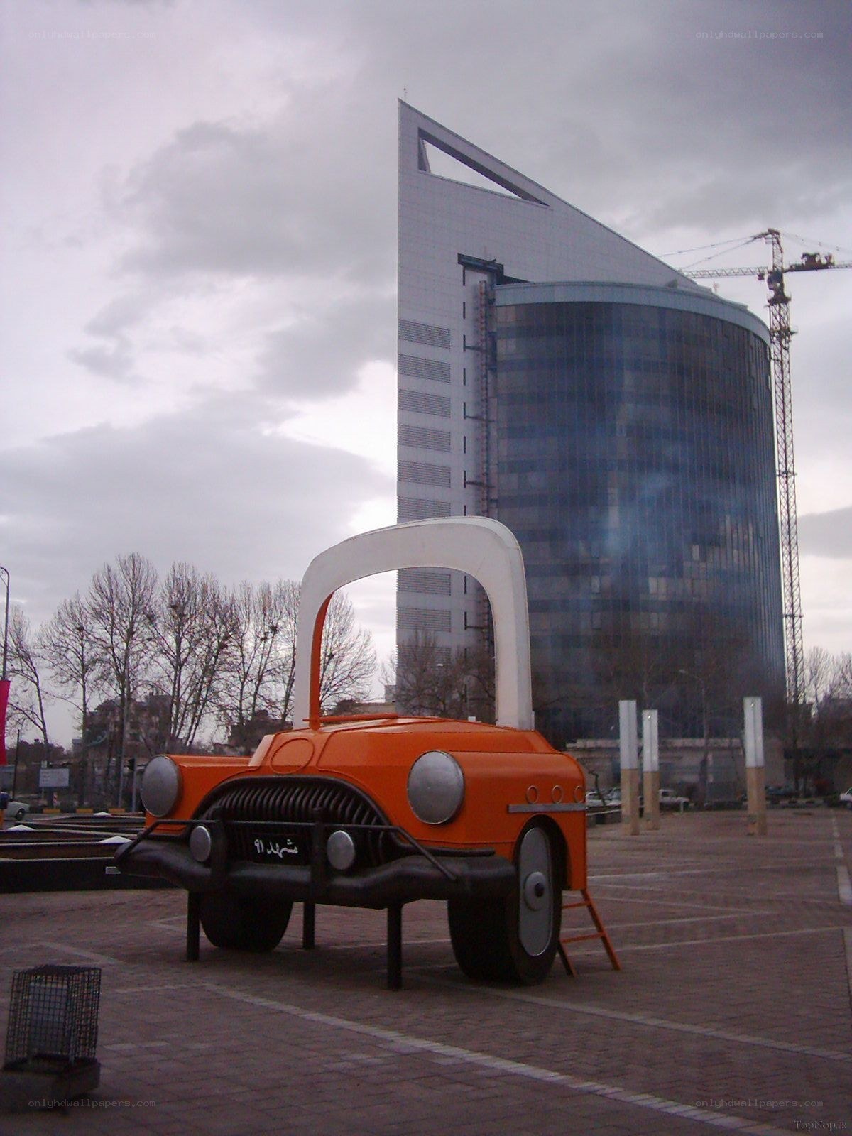Orange car sculpture in city