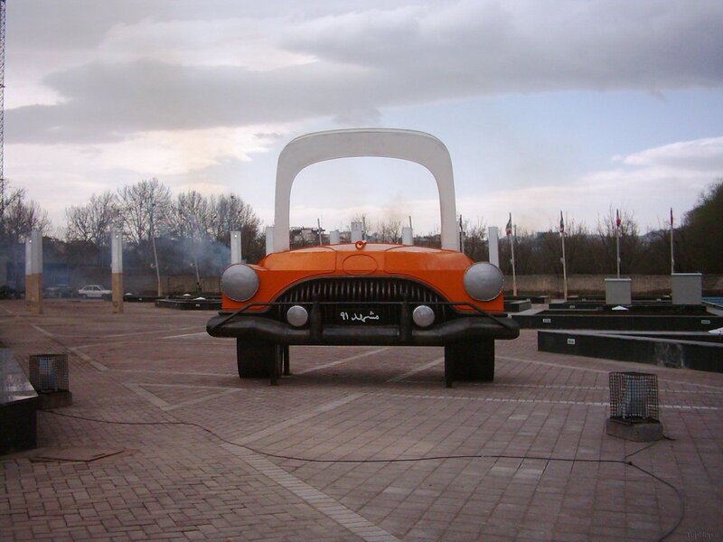 Orange car sculpture in plaza