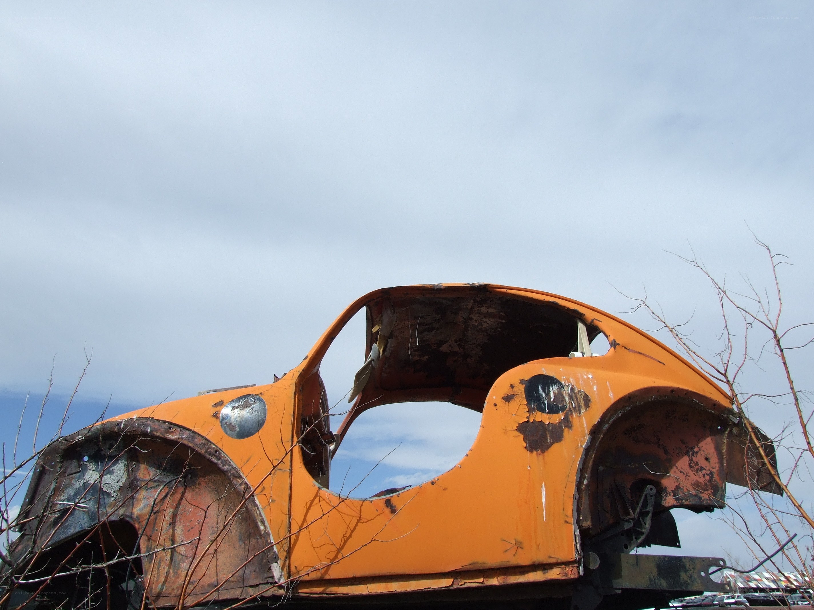Orange car shell in junkyard