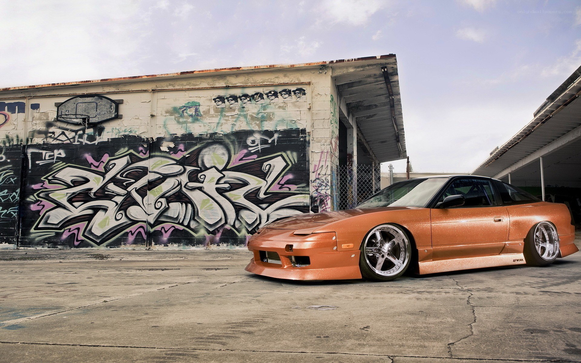 Orange car with graffiti wall