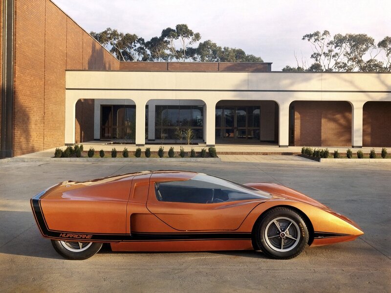 Orange concept car in front of building