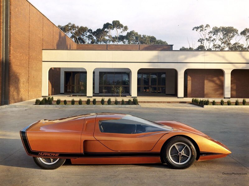 Orange concept car in front of building