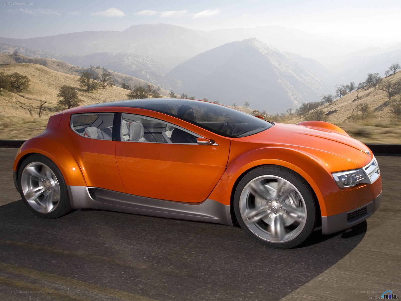 orange concept car on mountain road