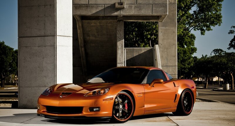 orange corvette parked by concrete structure