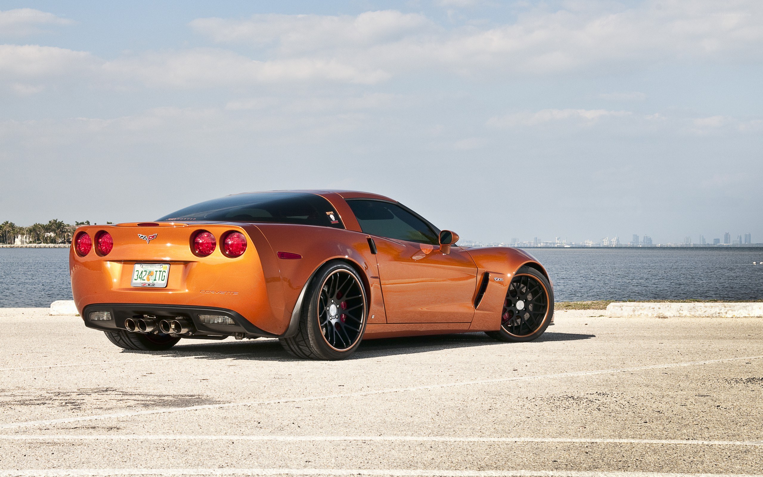 Orange Corvette parked by water
