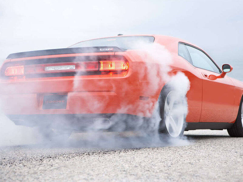 Orange Dodge Challenger burning rubber