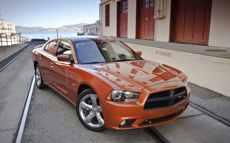 Orange Dodge Charger parked by water