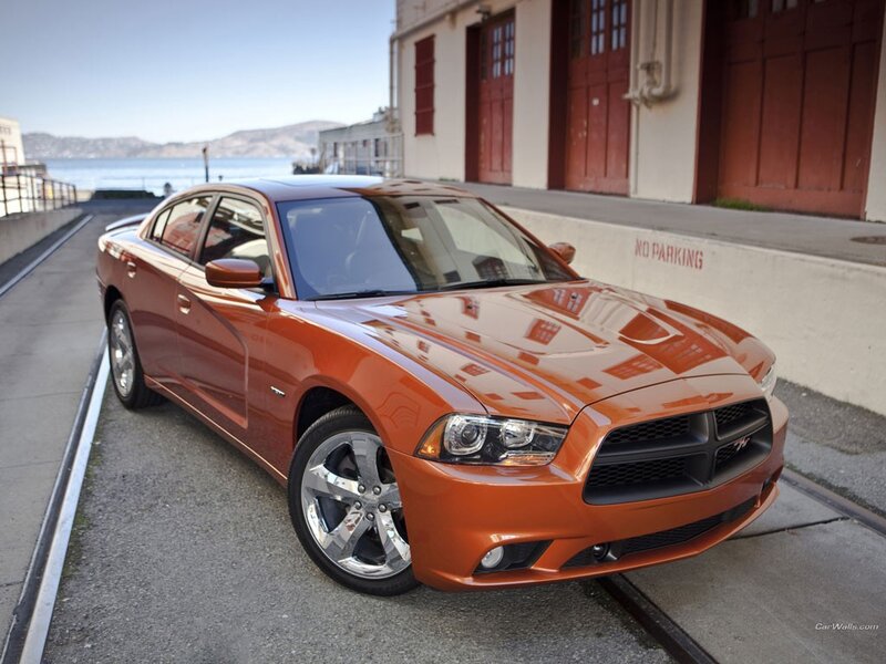 Orange Dodge Charger parked by water
