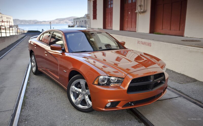 Orange Dodge Charger parked by water