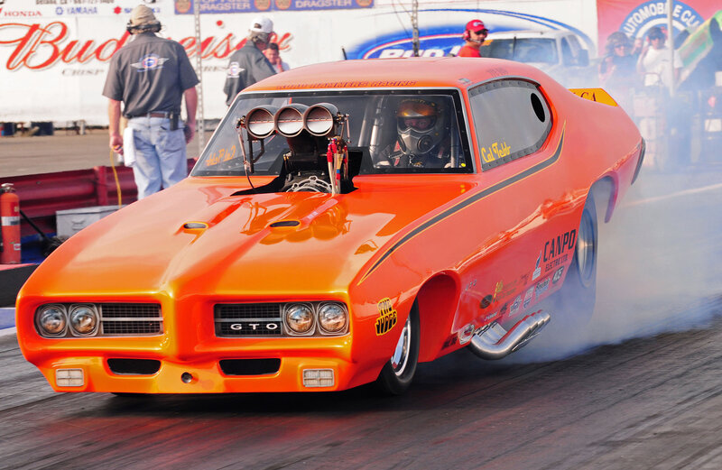 Orange drag racing car on track