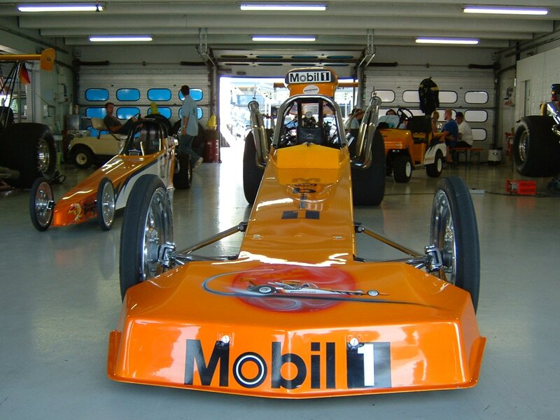 Orange drag racing cars in garage