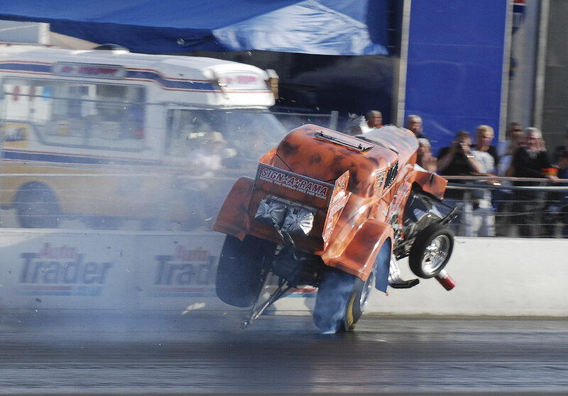 Orange dragster performing wheelie