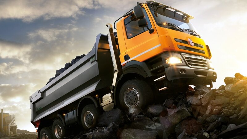 Orange dump truck on rocky terrain