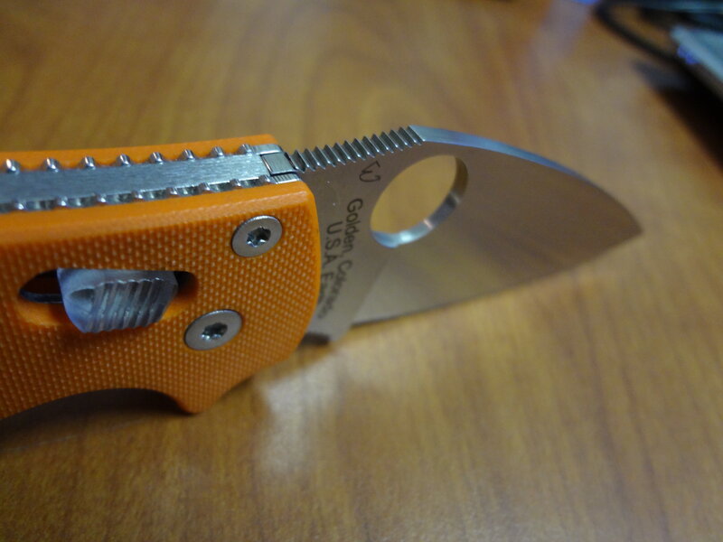 orange folding knife on table