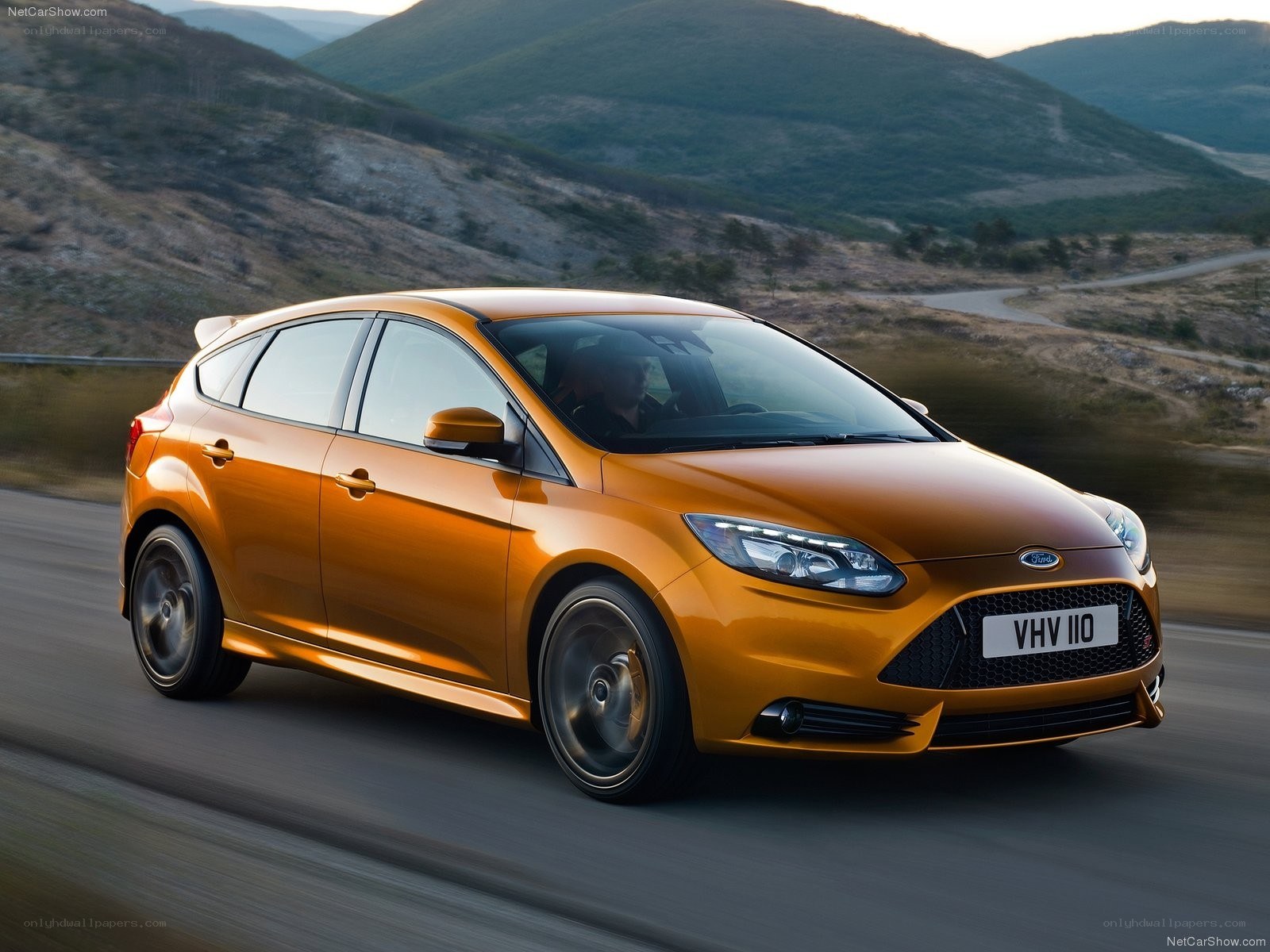 Orange Ford Focus driving on a road