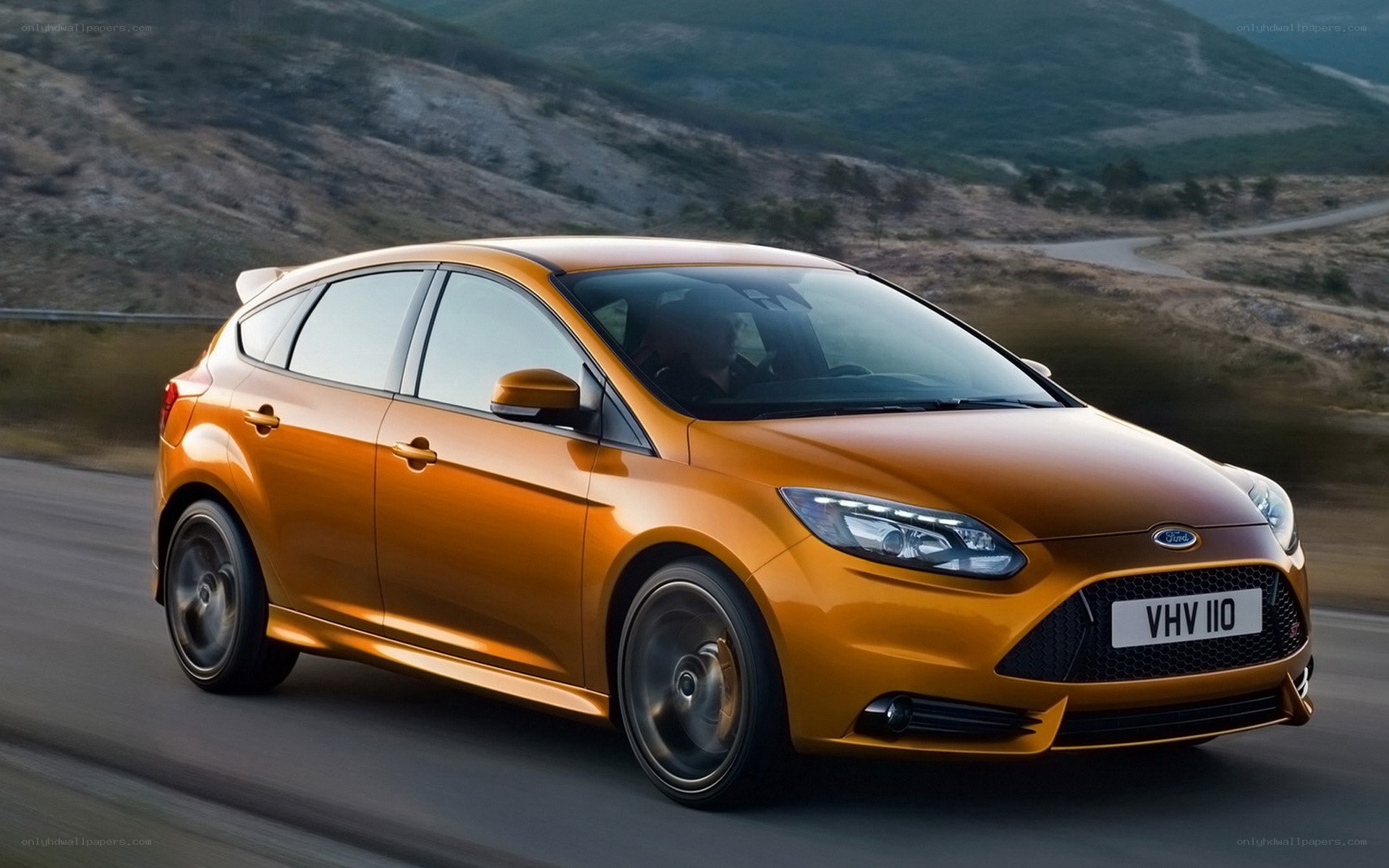 Orange Ford Focus driving on road