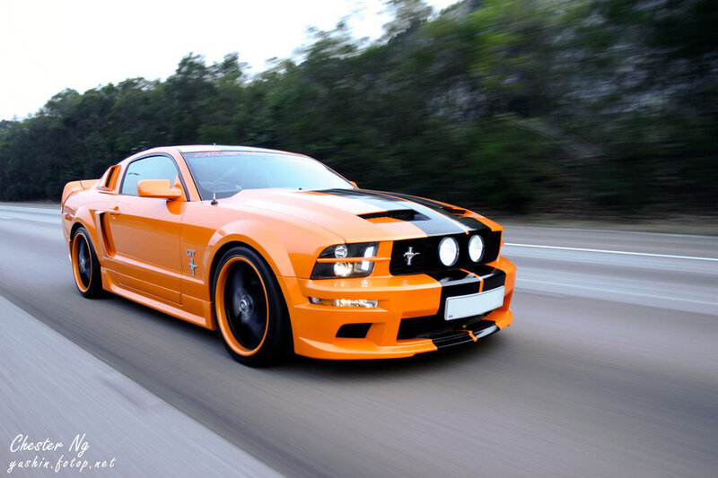 Orange Ford Mustang GT in motion