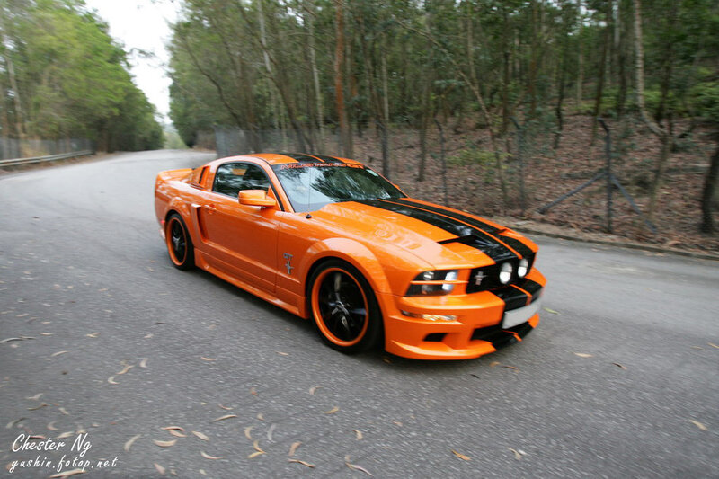 Orange Ford Mustang on a road