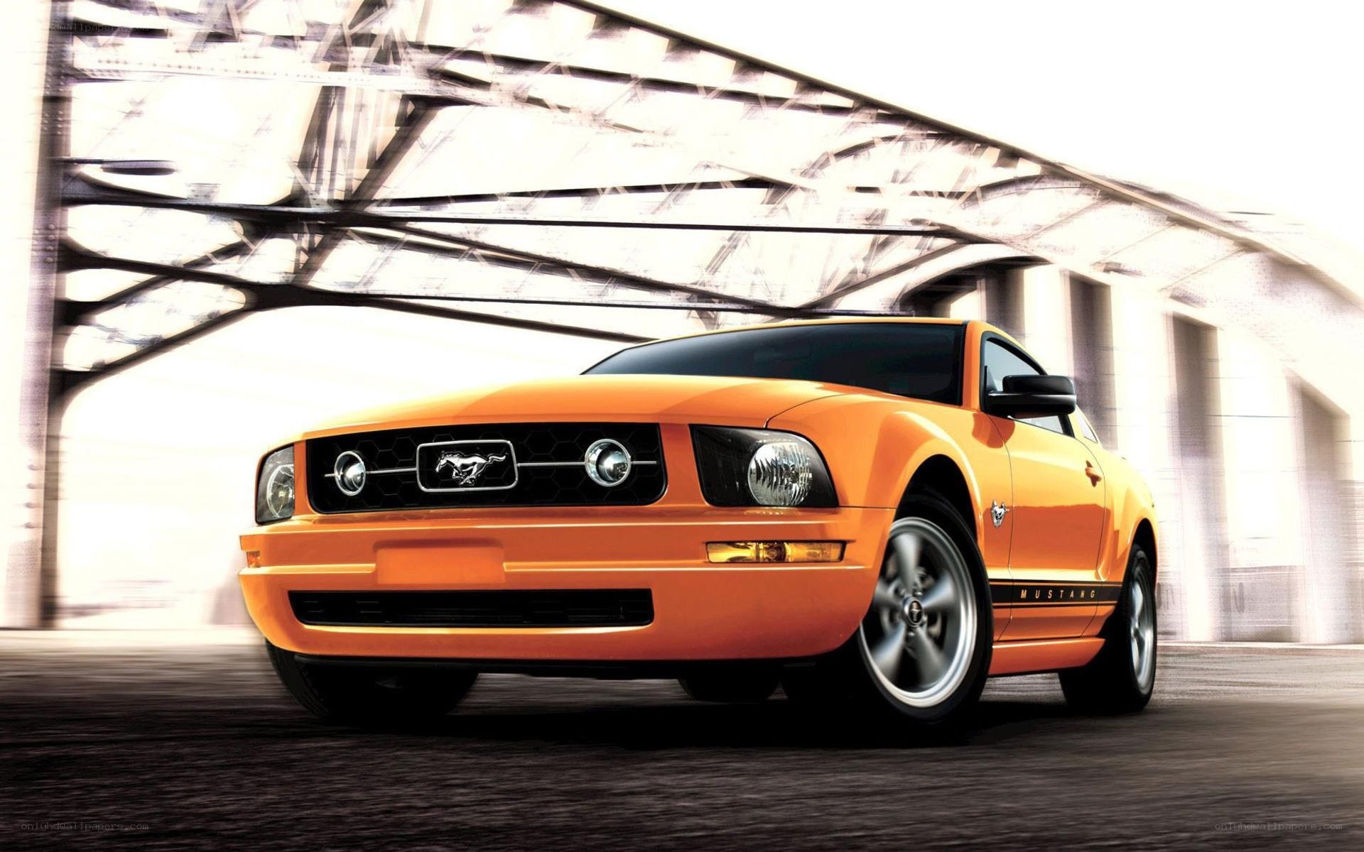 Orange Ford Mustang under bridge