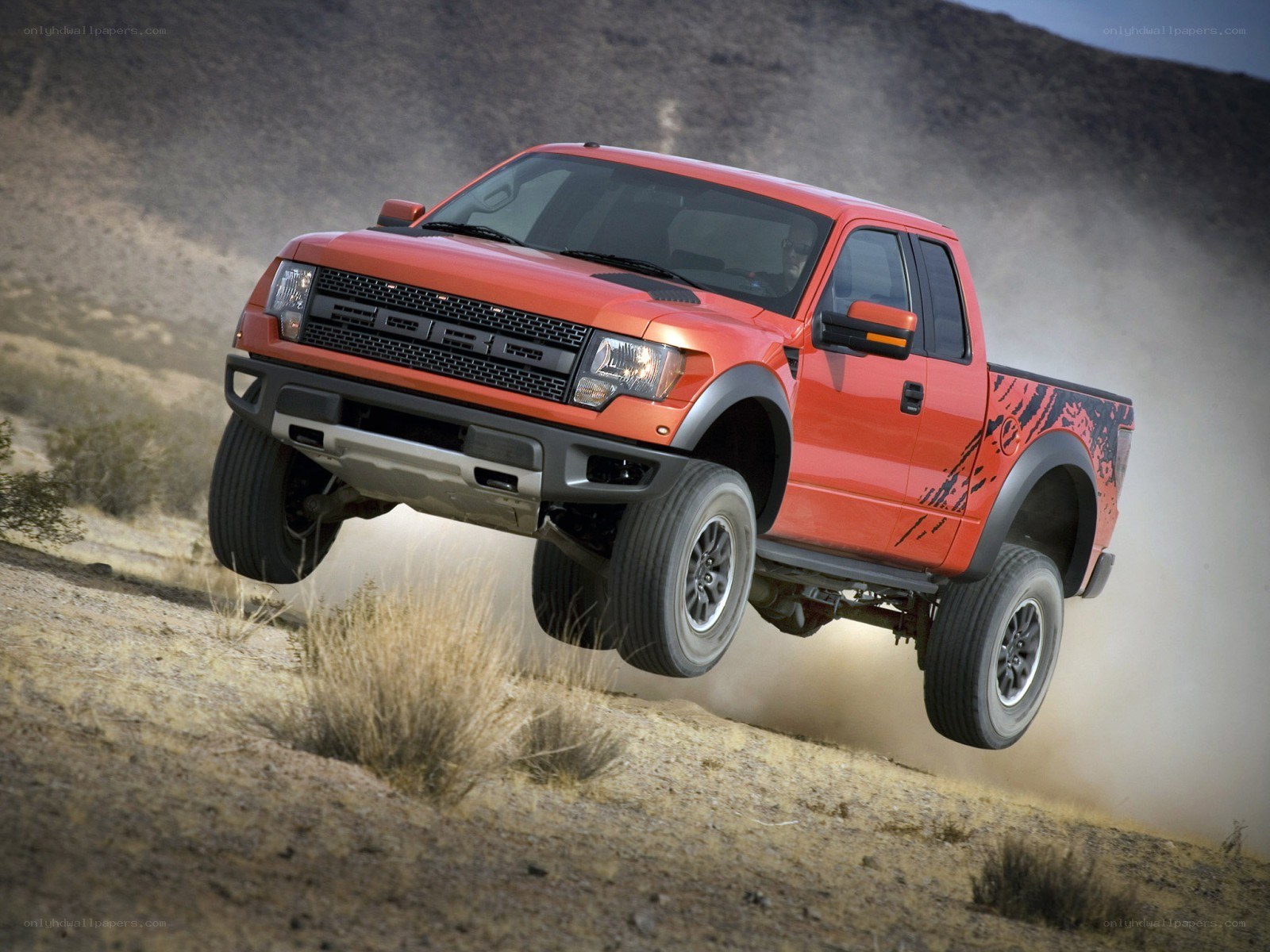 Orange Ford Raptor in desert