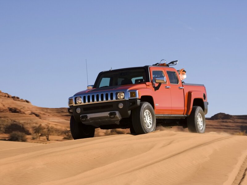 Orange Hummer driving on sand dunes