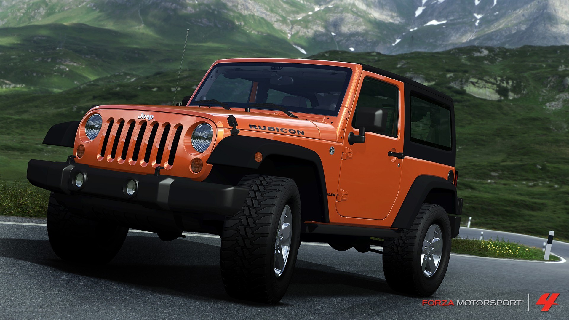 orange jeep rubicon on mountain road