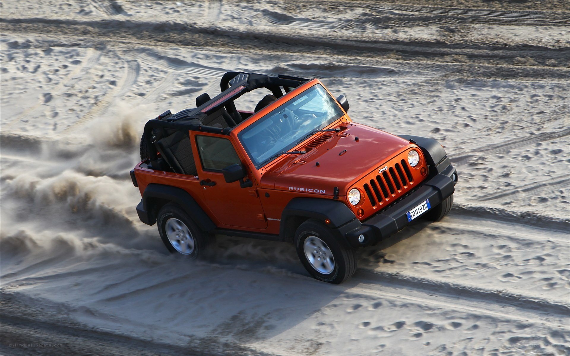 Orange Jeep Rubicon on sand
