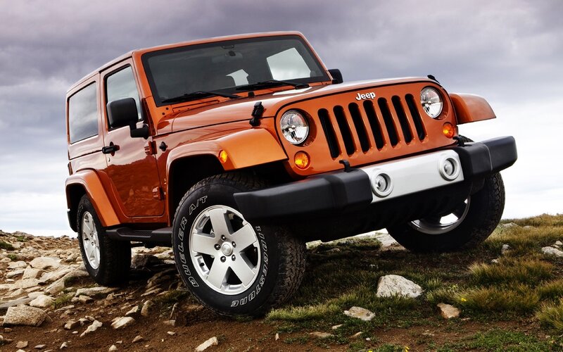 Orange Jeep Wrangler on rocky terrain