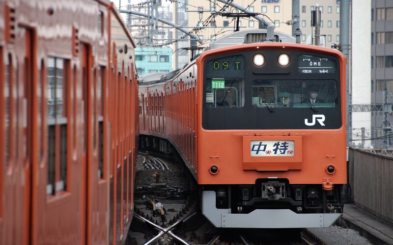 Orange JR train on tracks