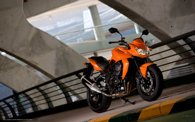Orange Kawasaki motorcycle under bridge