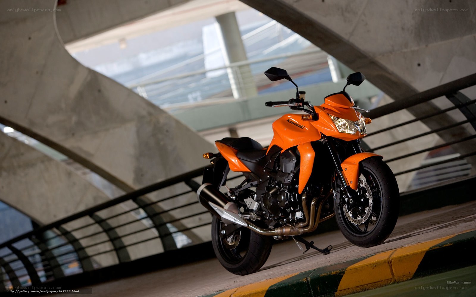 Orange Kawasaki motorcycle under bridge