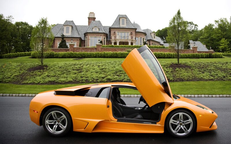 Orange Lamborghini in front of mansion