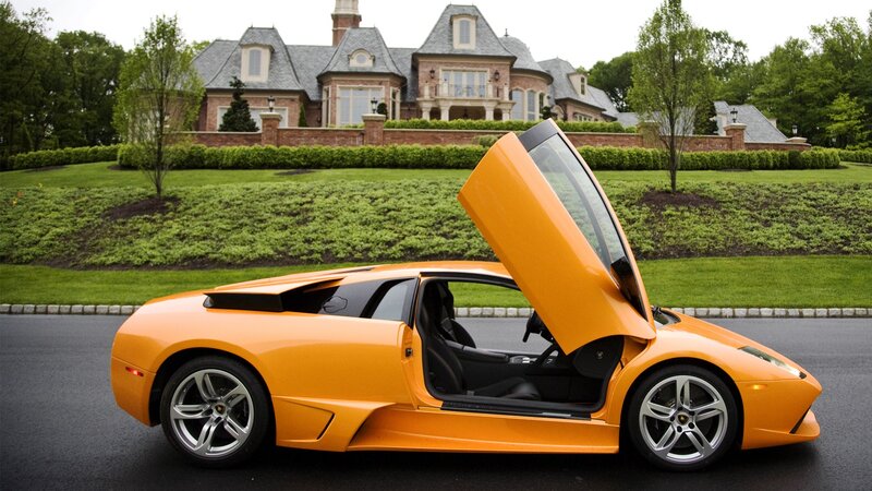 Orange Lamborghini in front of mansion