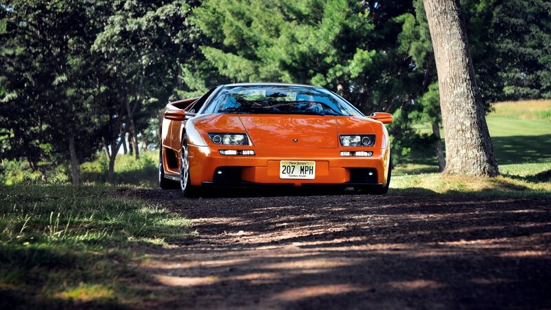 Orange Lamborghini on a dirt path