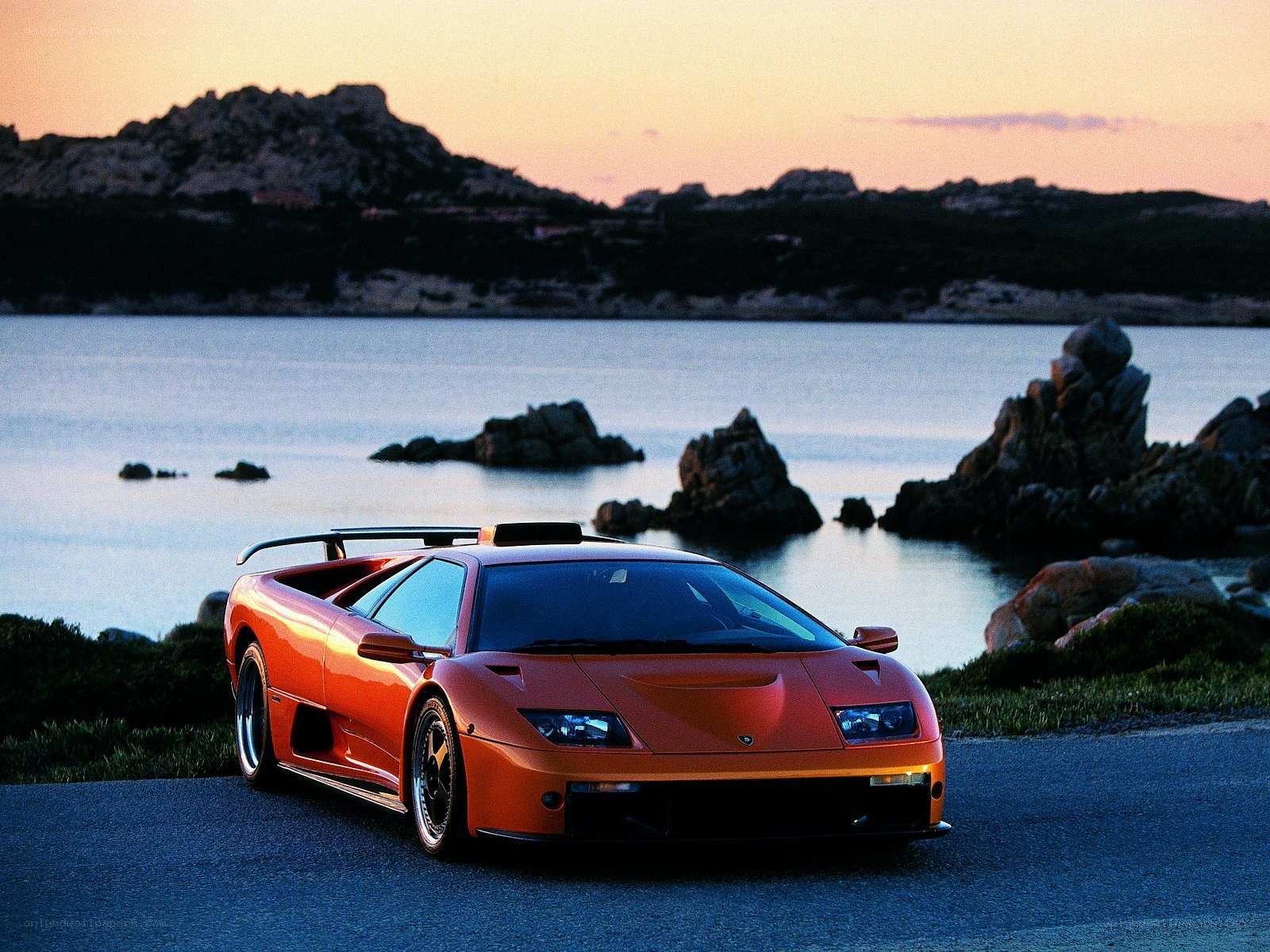 Orange Lamborghini on coastal road