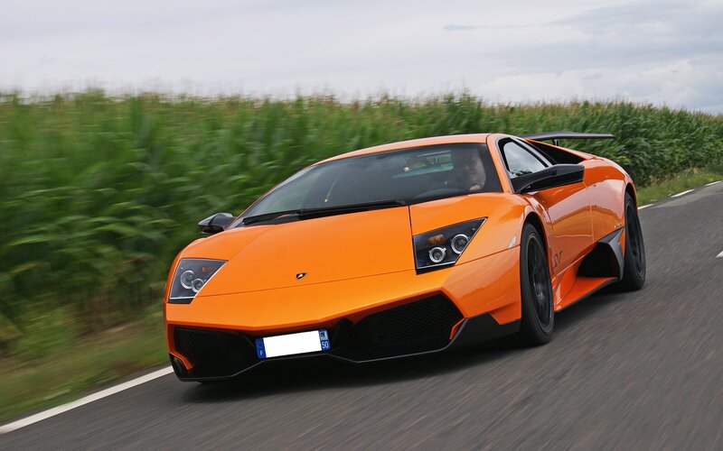 orange lamborghini on country road