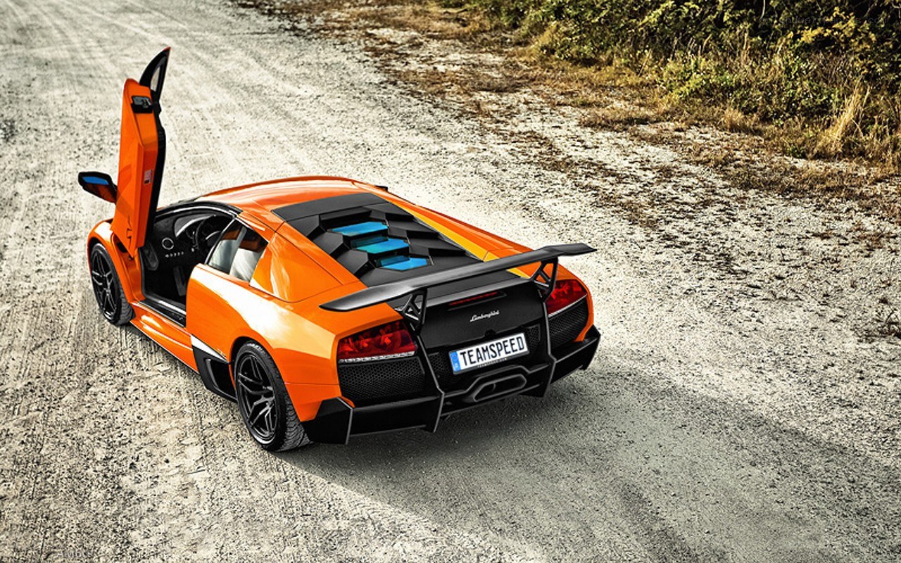 orange Lamborghini on dirt road