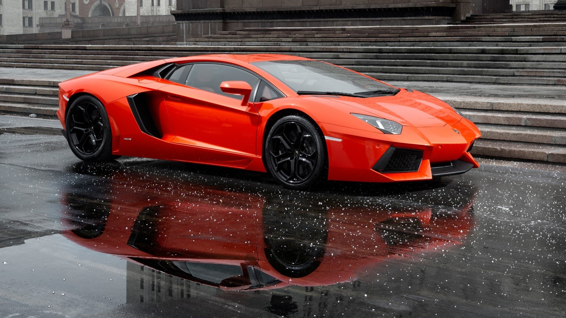 Orange Lamborghini on wet pavement