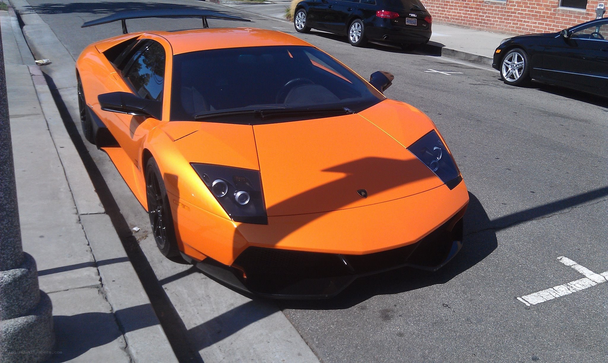 orange lamborghini parked on street