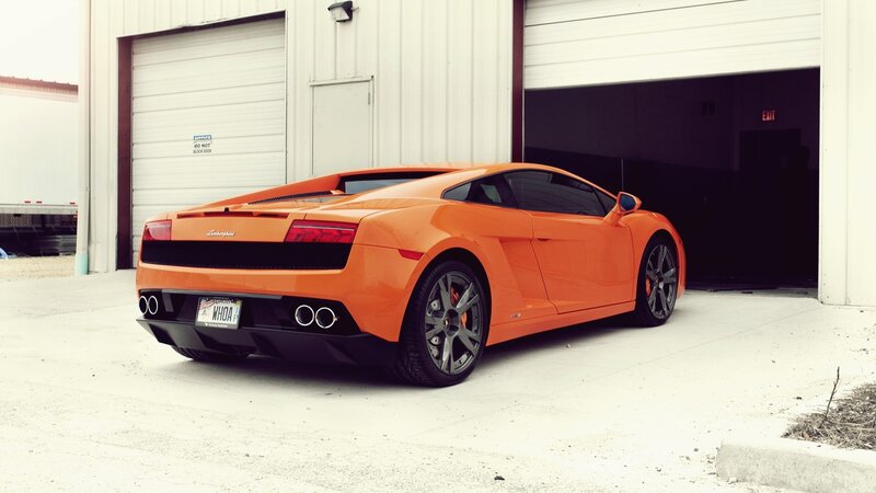 orange Lamborghini parked outside garage