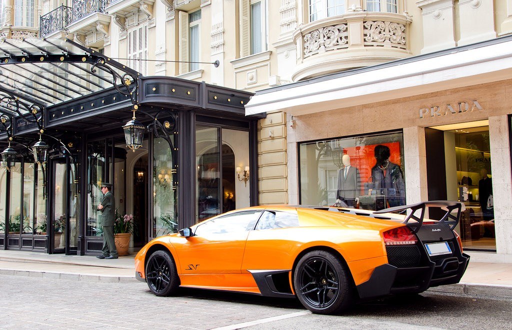 Orange Lamborghini parked outside hotel